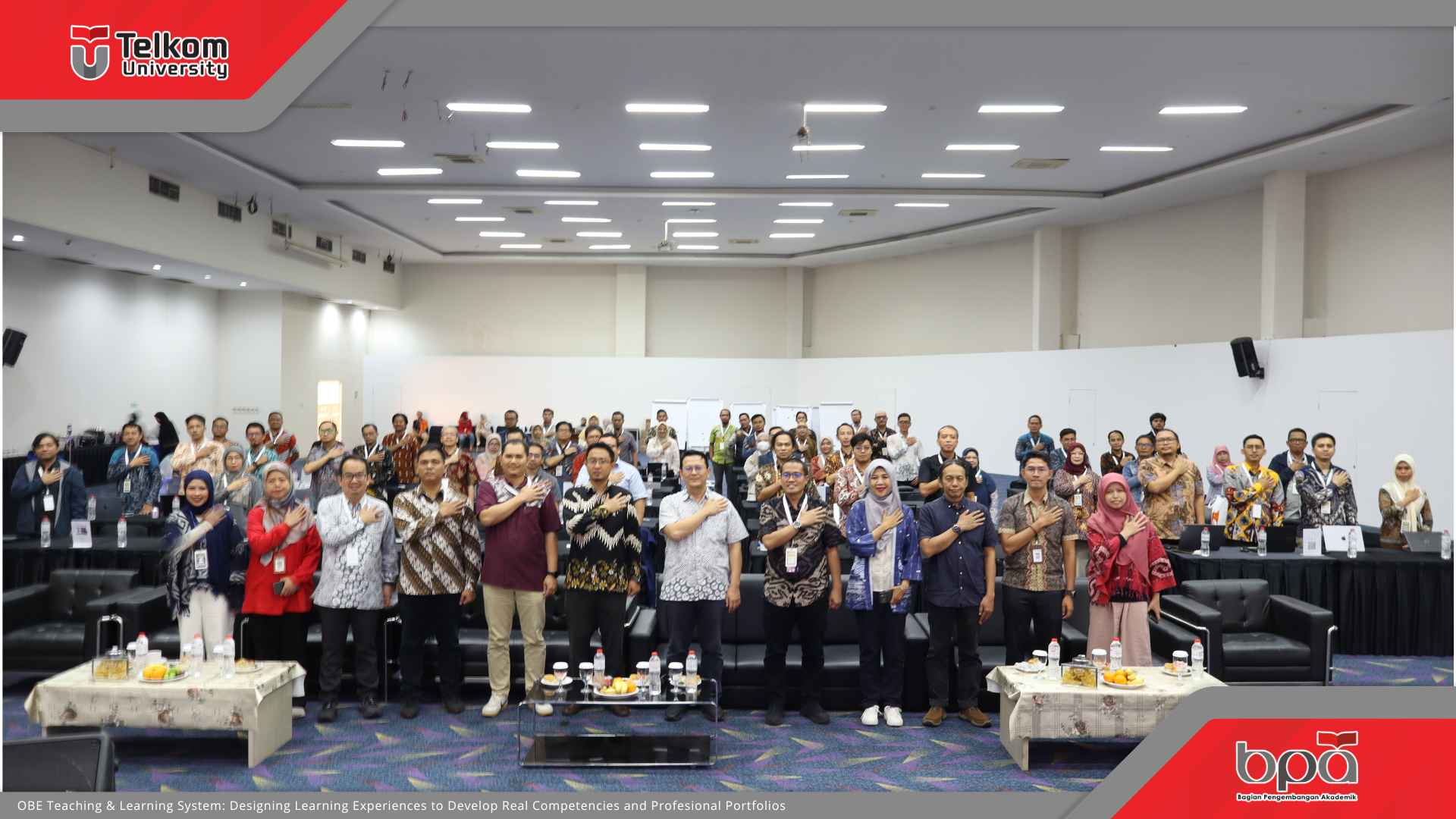 Foto bersama peserta seminar di Universitas Telkom dengan latar belakang panggung dan logo BPA, mengusung tema "OBE Teaching & Learning System: Designing Learning Experiences". Para peserta berpose hormat tangan di dada.